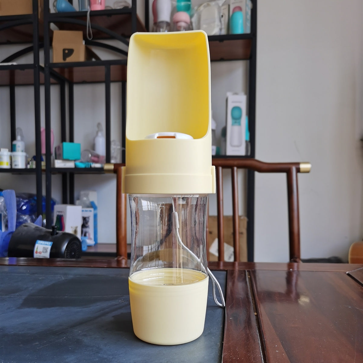 Yellow ROAM Bottle with the trough open, photographed on a table